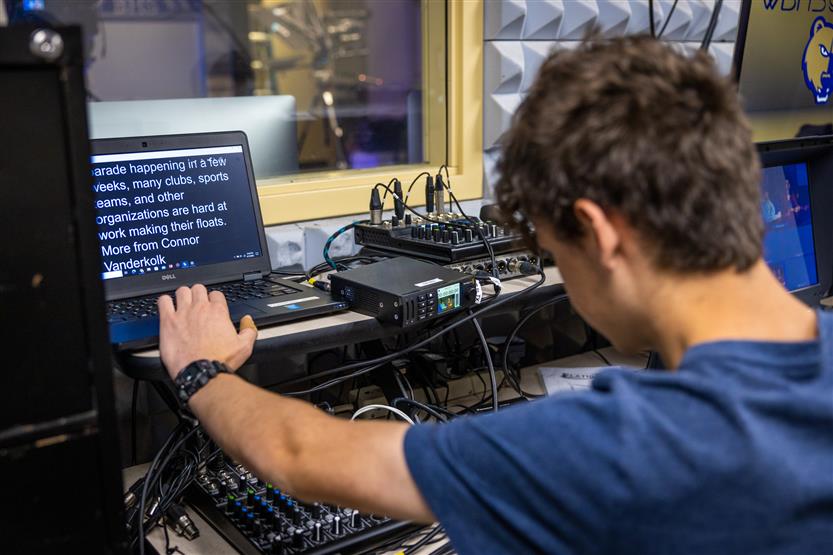 A student works with audio during a news recording